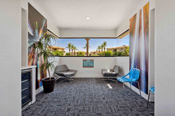 A room with a grey carpet and a large poster on the wall.